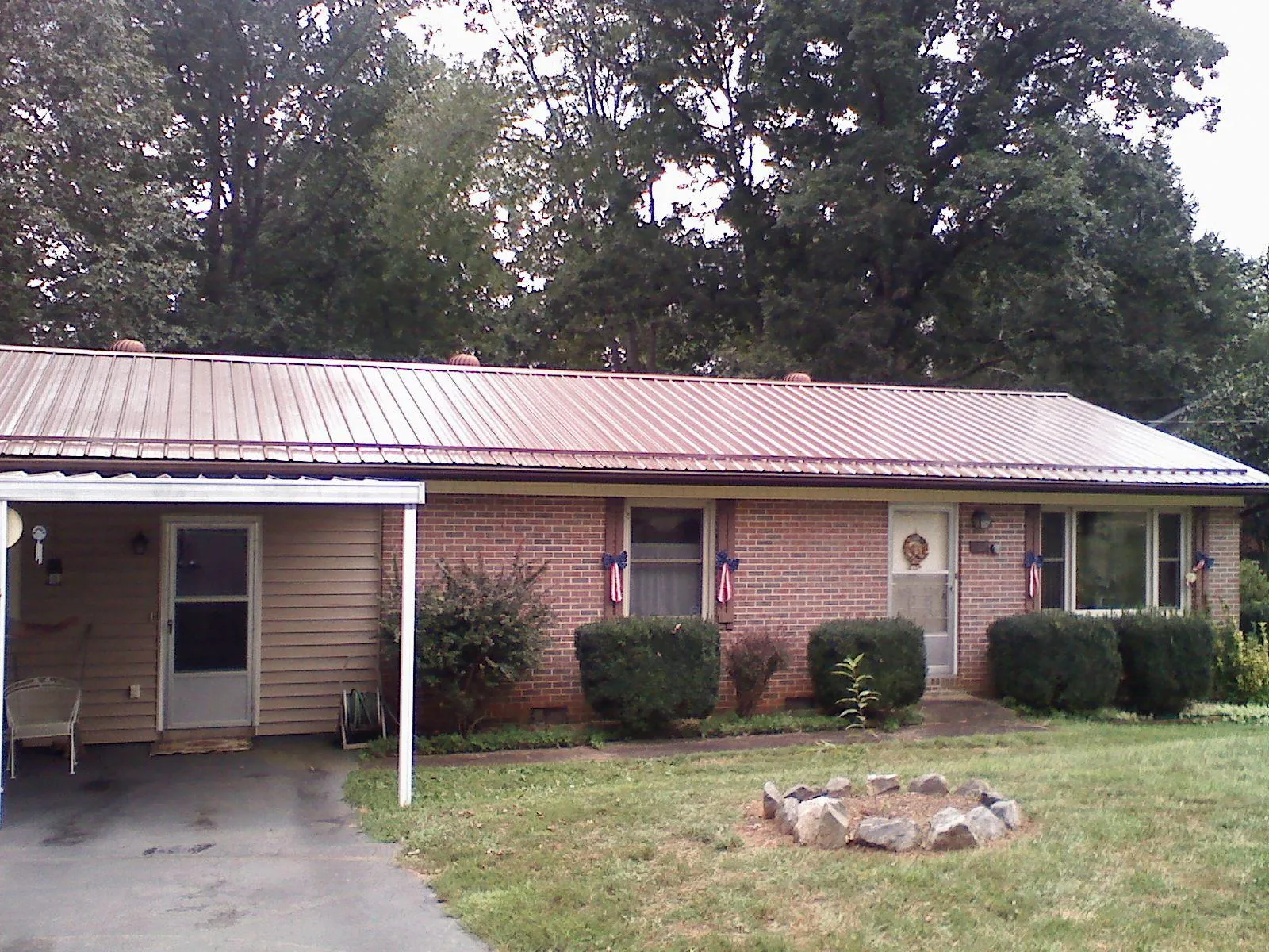 Bronze metal roof and carport on a brick ranch home — Roof Repair work by our crew in Carthage